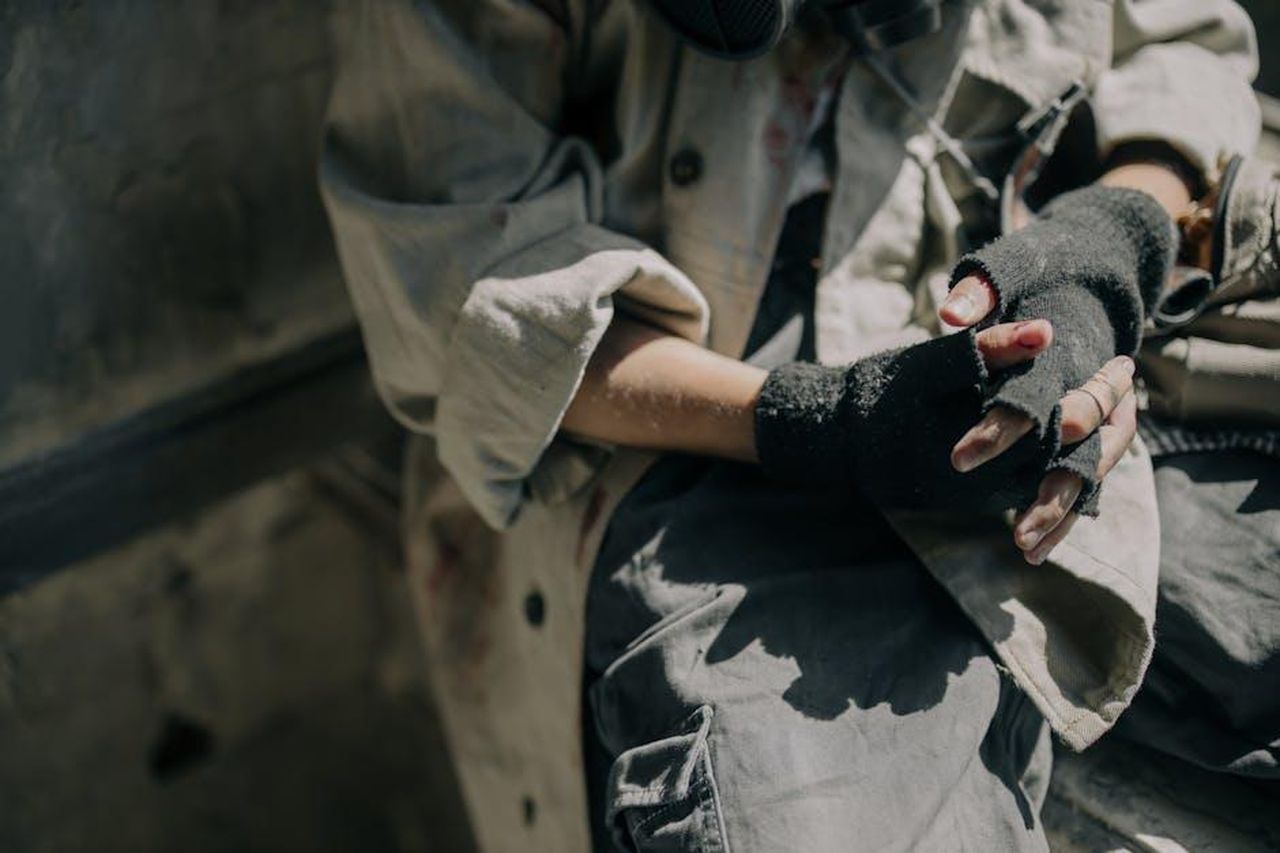 Helena_Prestes_sotto_attacco_al_Grande_Fratello_6NGwbhwU7D - Confidenze24 Source: cottonbro studio - pexels - Mysterious figure in dystopian setting wearing fingerless gloves, illustrating a survival theme.