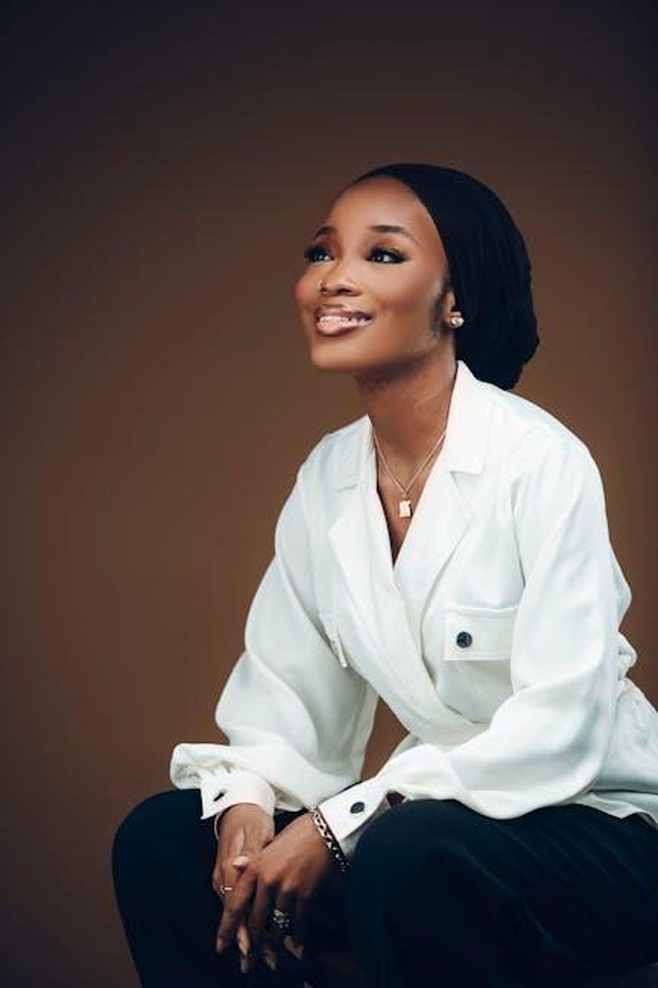 Henry_Kelly_uR8Eoh34O1 - Confidenze24 Source: Darkshade Photos - pexels - Elegant portrait of a smiling woman in business attire, exuding confidence and style.