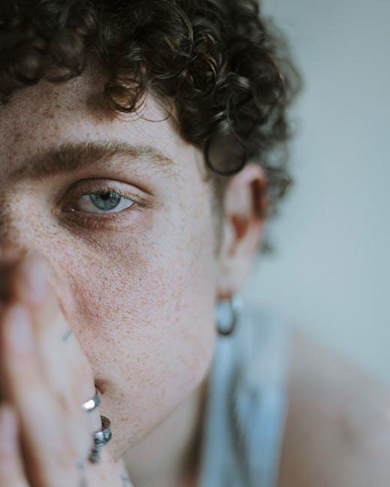 I_fan_si_chiedono_se_Bobby_torner_in_Tracker_TGfIu6sGfL - Confidenze24 Source: sahar photography - pexels - Close-up portrait of a young adult with curly hair and freckles, deep in thought.