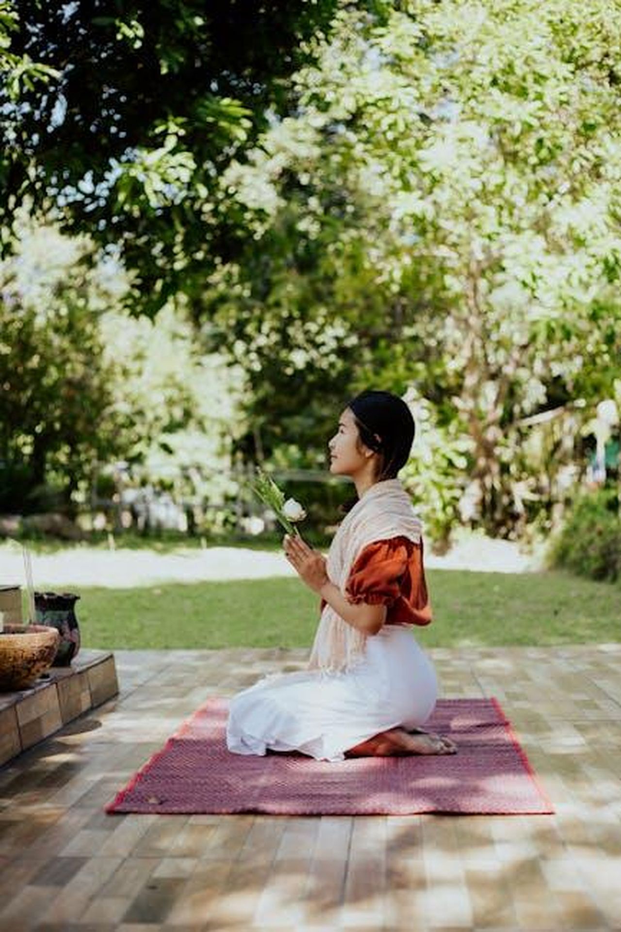 Il_Ruolo_della_Fede_nella_Vita_di_Savannah_WWwcjvvtpr - Confidenze24 Source: cottonbro studio - pexels - A woman kneeling outdoors, praying with a flower in a serene garden setting.