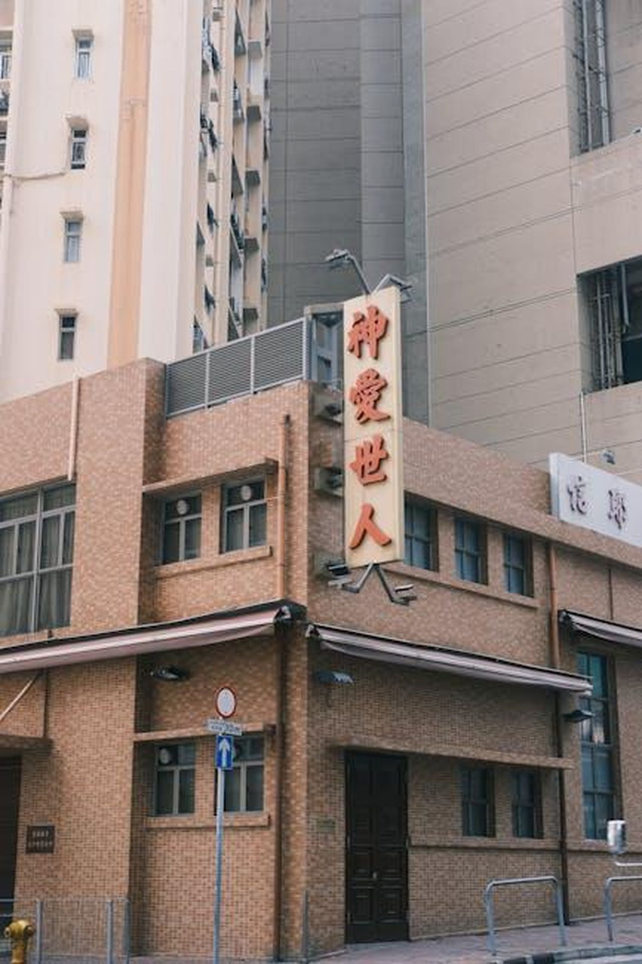 Il_Teaser_e_i_Personaggi_b1YsjLhfkO - Confidenze24 Source: Junchen Zhou - pexels - Urban street corner featuring a building with traditional Chinese characters and signage.