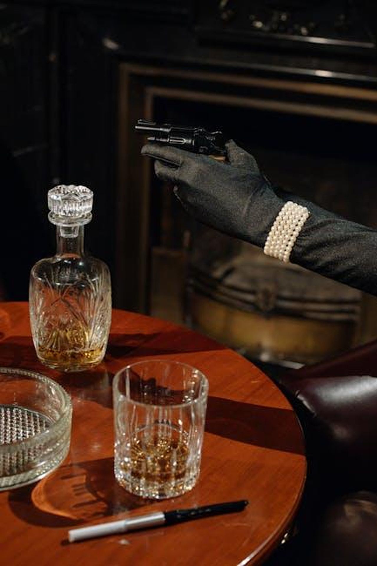 Il_colpo_di_scena_finale_B3qivbttRq - Confidenze24 Source: cottonbro studio - pexels - Cinematic noir scene featuring a gloved hand with a gun and a whiskey setup.