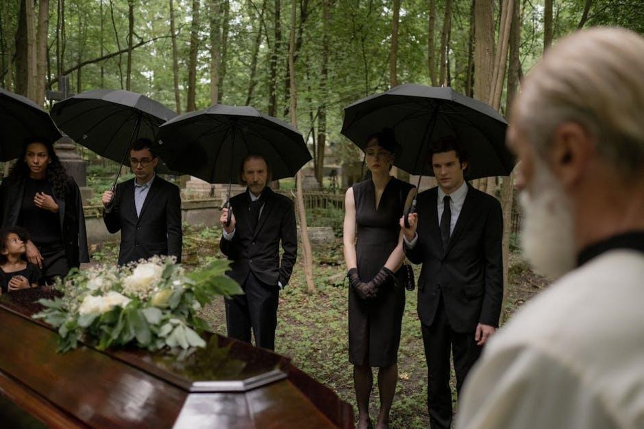 Il_commovente_eulogio_di_Ja_Rule_VzlKrCnG8c - Confidenze24 Source: cottonbro studio - pexels - A group mourns during a funeral gathering in a forest cemetery.