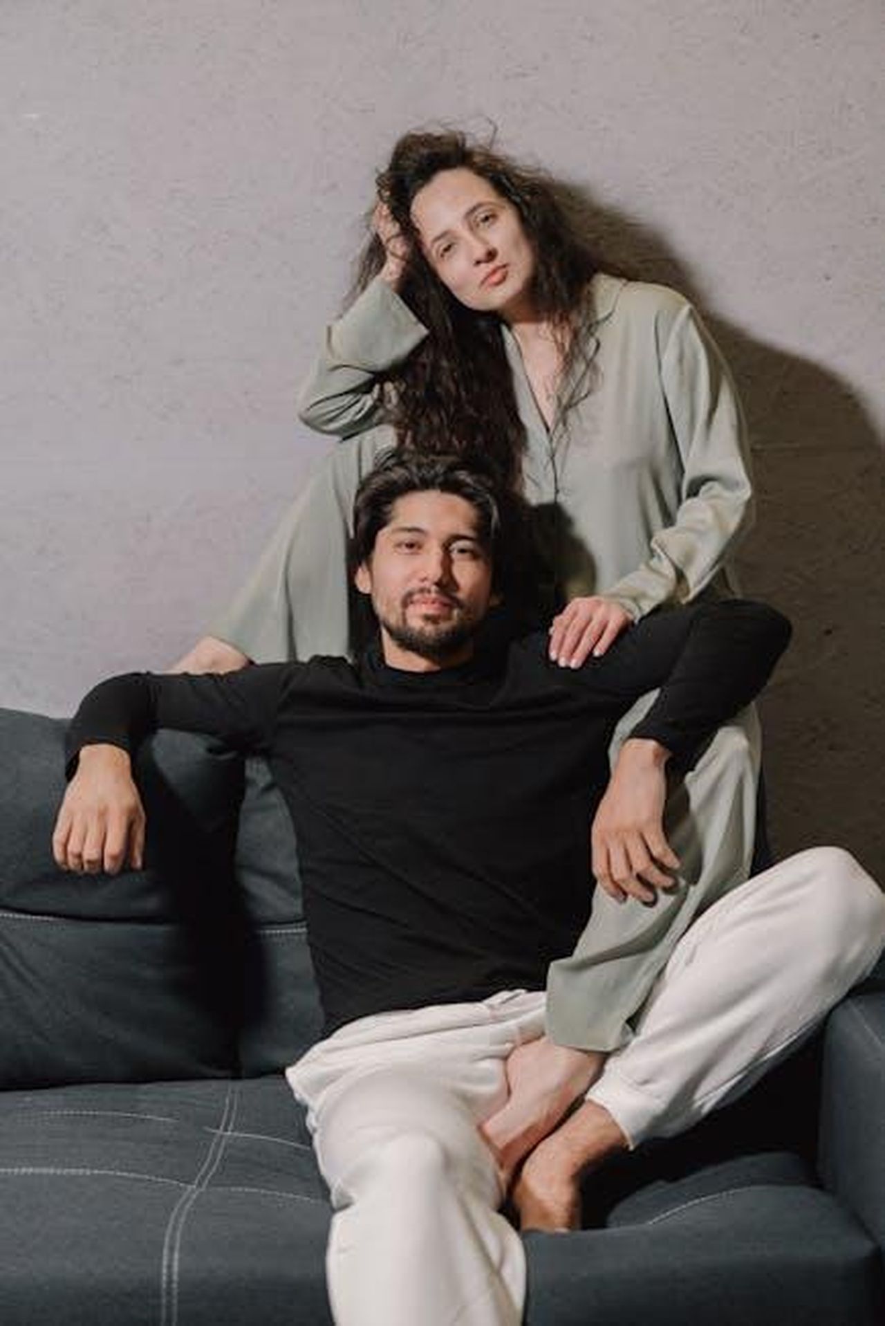 Il_freno_di_Helena_AiPhDI598H - Confidenze24 Source: Mikhail Nilov - pexels - Elegant couple sitting together, exuding calm and comfort in a stylish home setting.