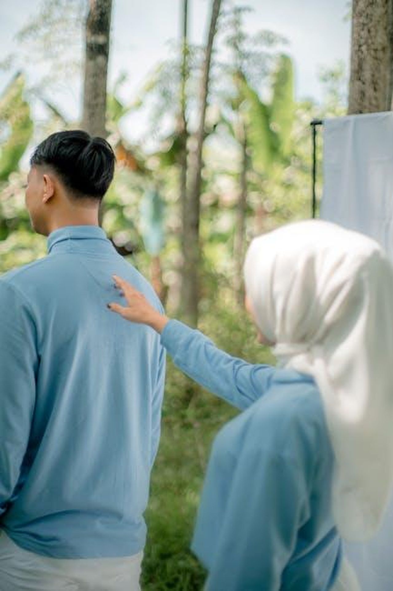 Il_futuro_di_Travis_e_Taylor_J9WmWgUKOl - Confidenze24 Source: kriisszzz kriisszzz - pexels - Couple in blue attire enjoying a prewedding session in a lush outdoor setting.