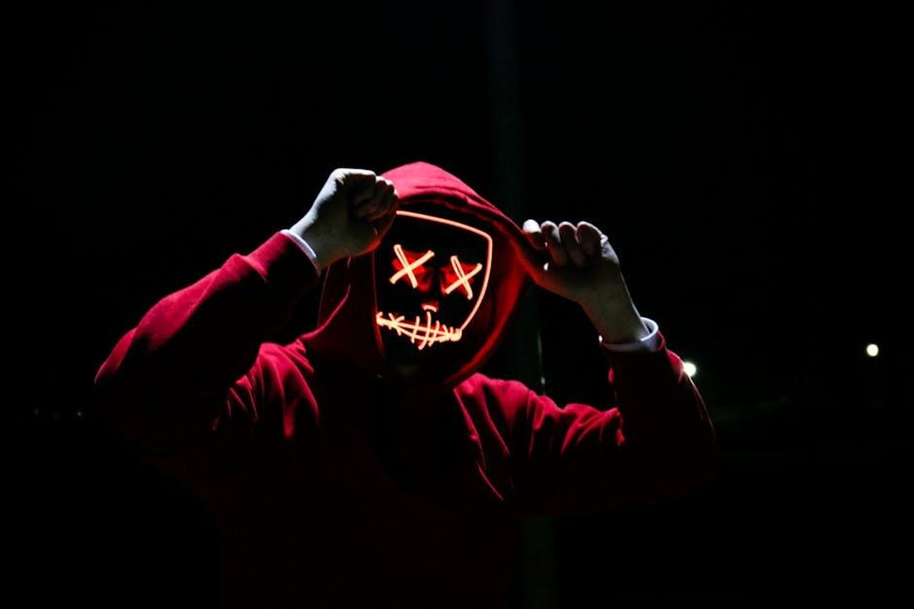 Il_lato_oscuro_di_Gregorio__costato_quasi_la_vita_a_Pia_dusa4s3D4C - Confidenze24 Source: Sebastiaan Stam - pexels - A spooky illuminated mask figure with a red hoodie in a dark setting, perfect for Halloween themes.