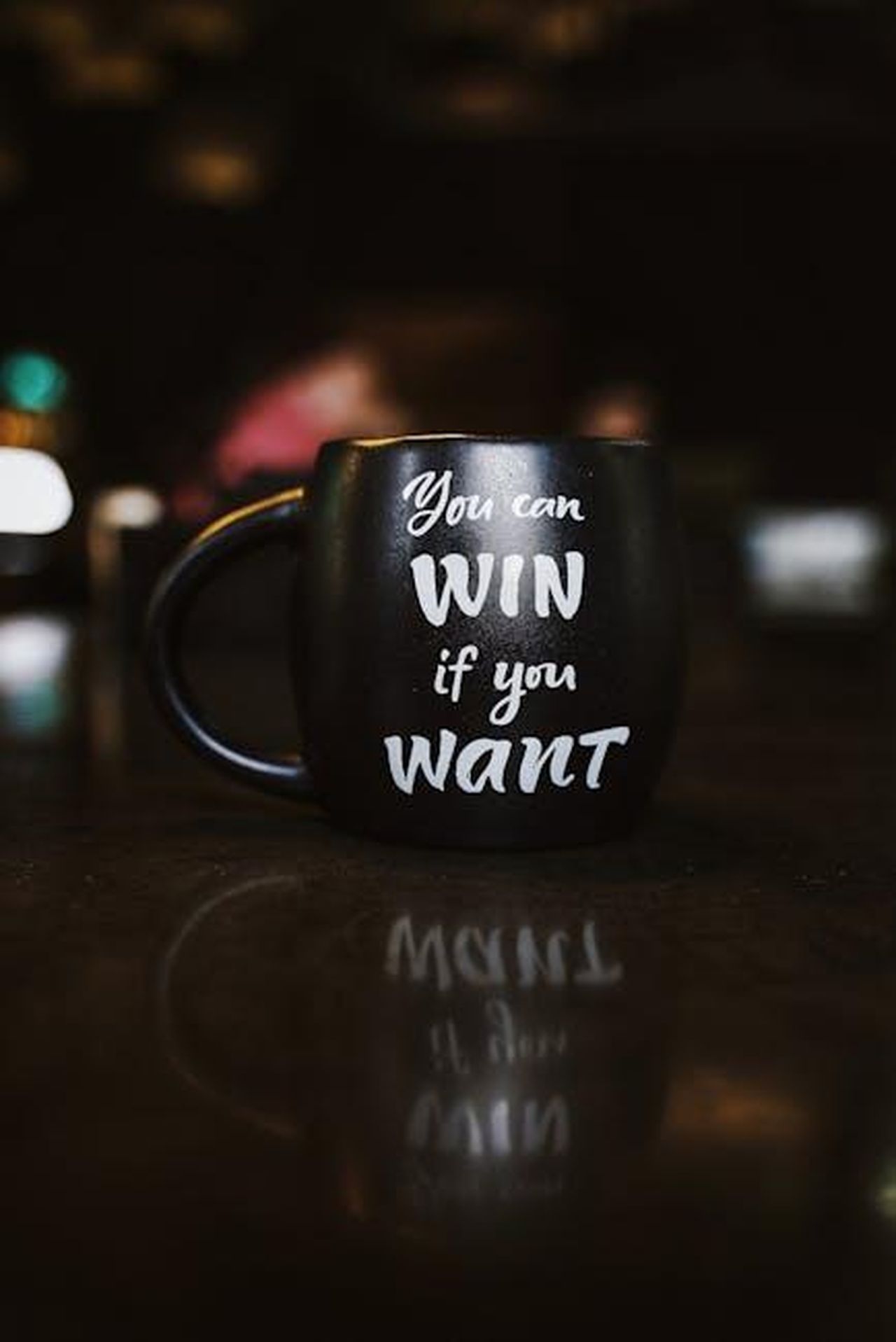 Il_messaggio_di_Bianca_Balti_continua_a_brillare_dYJuh8hfMM - Confidenze24 Source: Olena Bohovyk - pexels - Black mug with inspirational quote 'You can win if you want' reflected on a dark surface, creating a motivational ambiance.