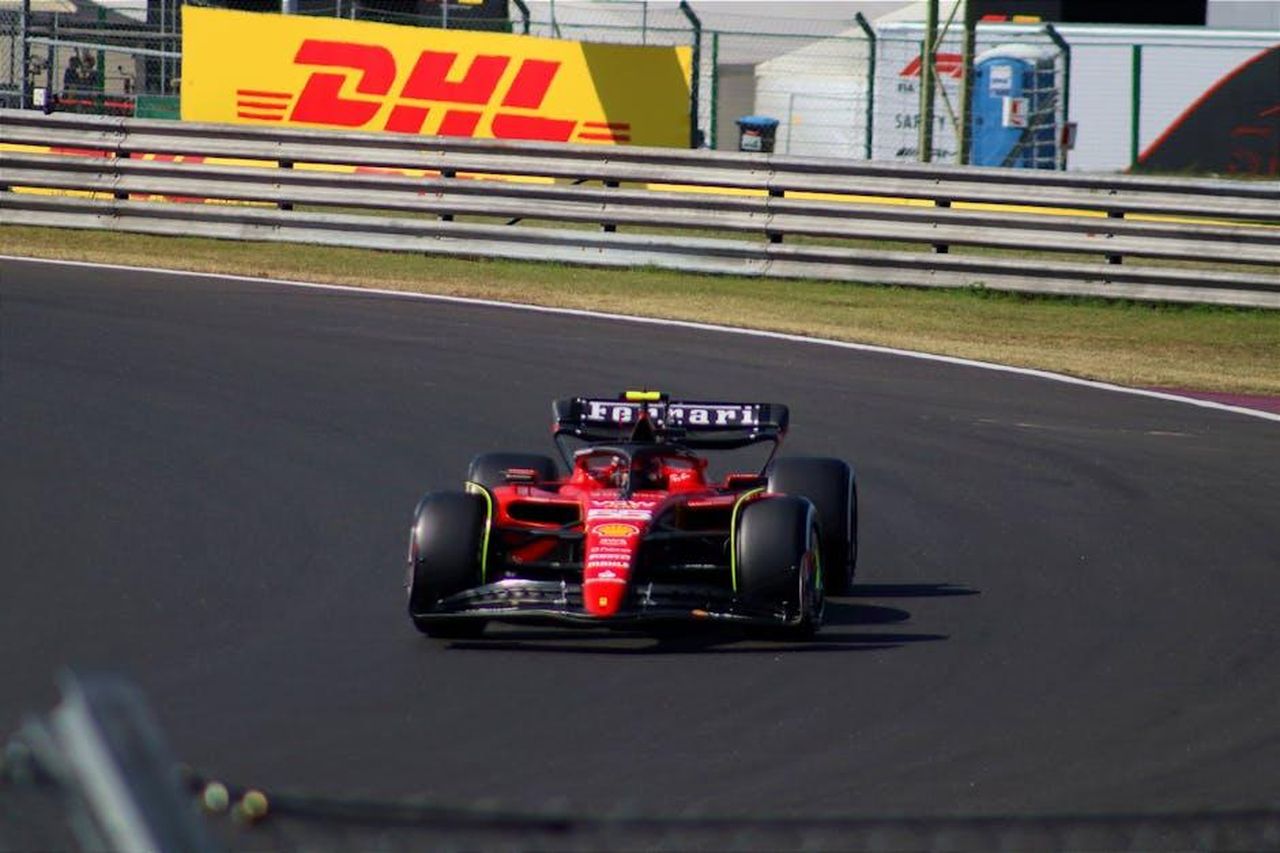 Il_parere_degli_spettatori_D7M2ttu70k - Confidenze24 Source: Botond Dobozi - pexels - Scuderia Ferrari Formula 1 car racing at Mogyoród track, showcasing speed and precision.