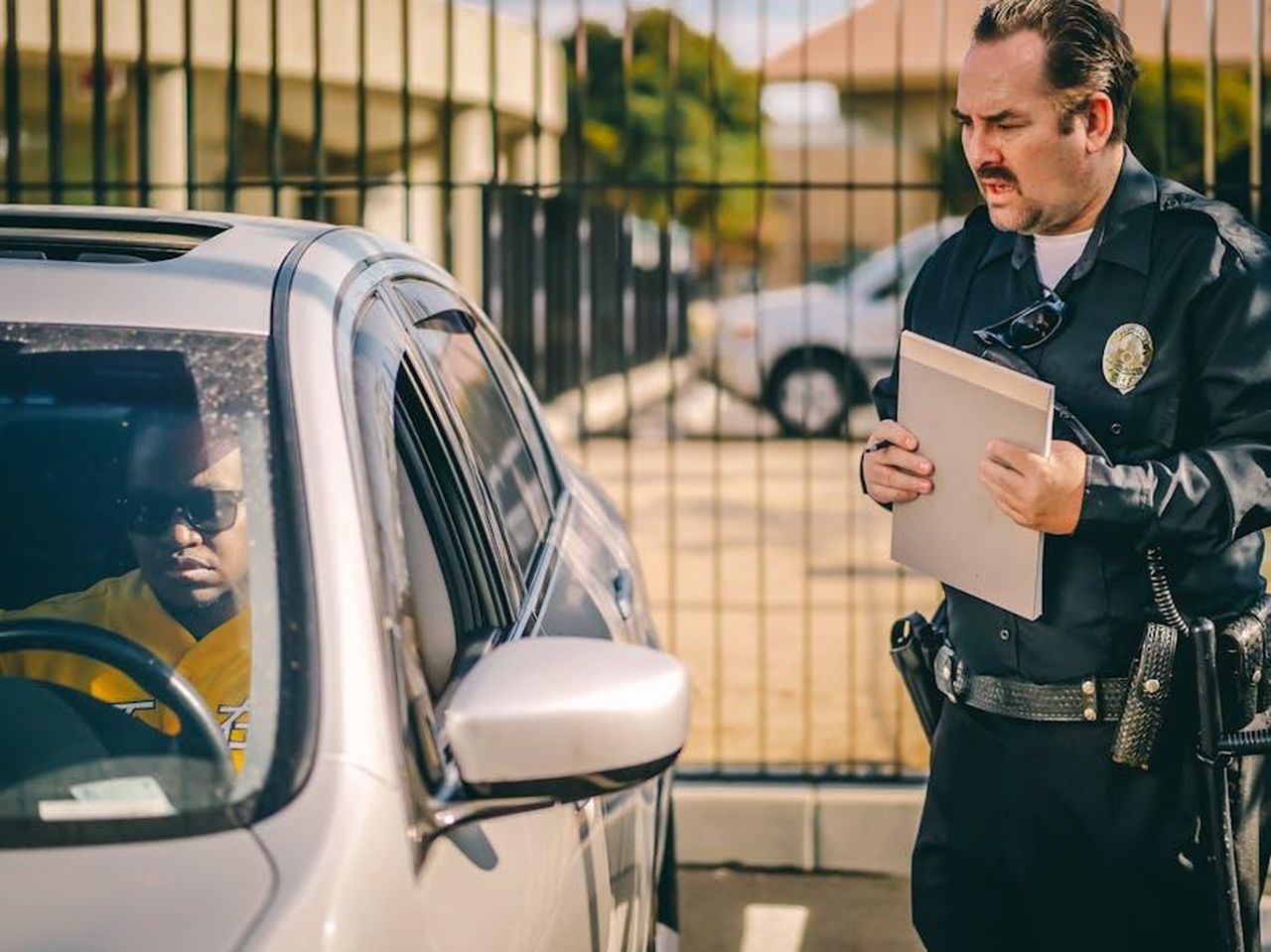 Il_primario_riceve_un_avviso_di_garanzia_aruWsfnfjJ - Confidenze24 Source: Kindel Media - pexels - Police officer at car window issuing a ticket to a driver in a sunny outdoor setting.