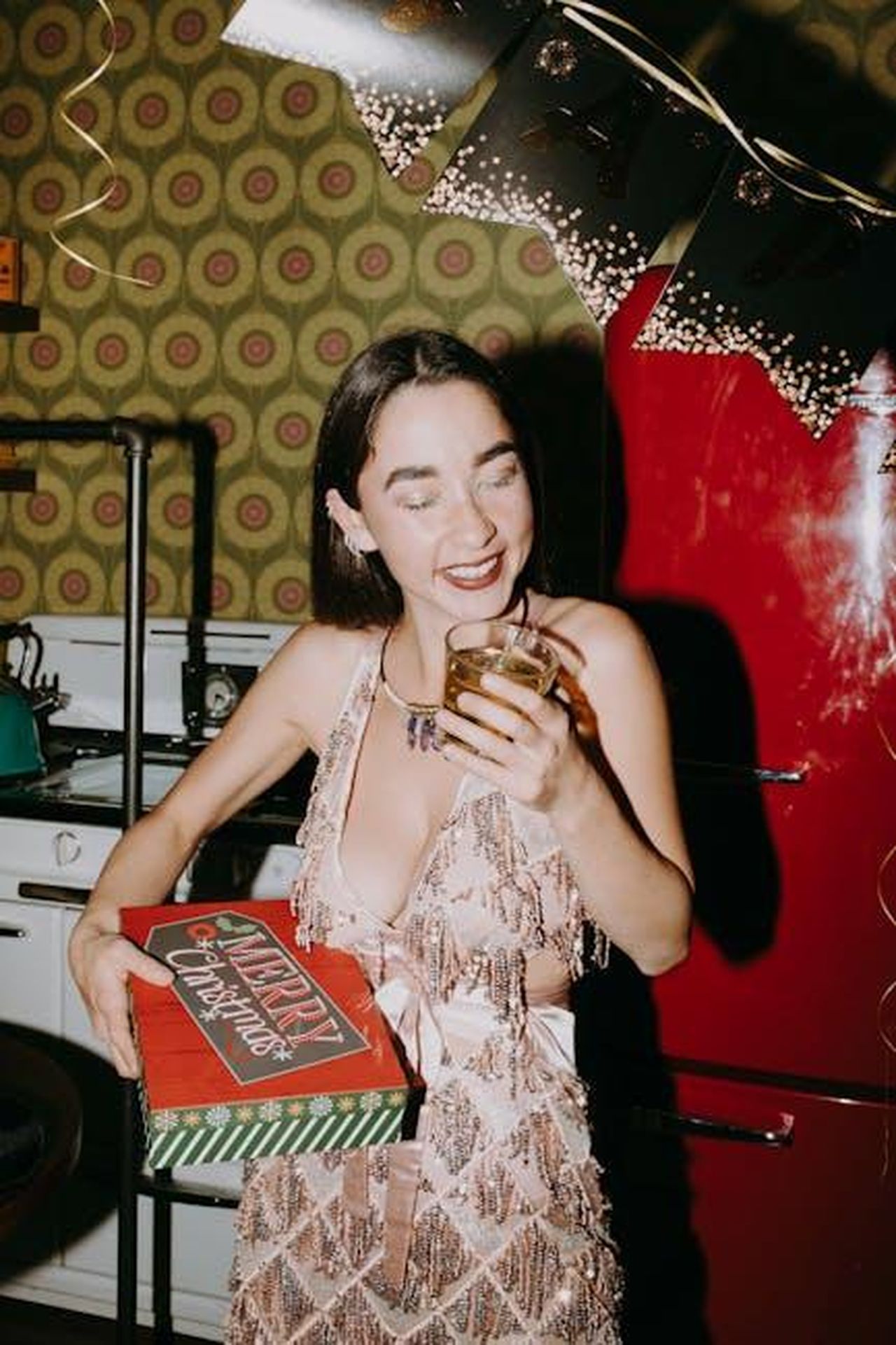 Il_primo_video_postato_su_Instagram_b9JbUt7iCu - Confidenze24 Source: RDNE Stock project - pexels - Smiling woman in festive dress with drink, celebrating in a retro kitchen.