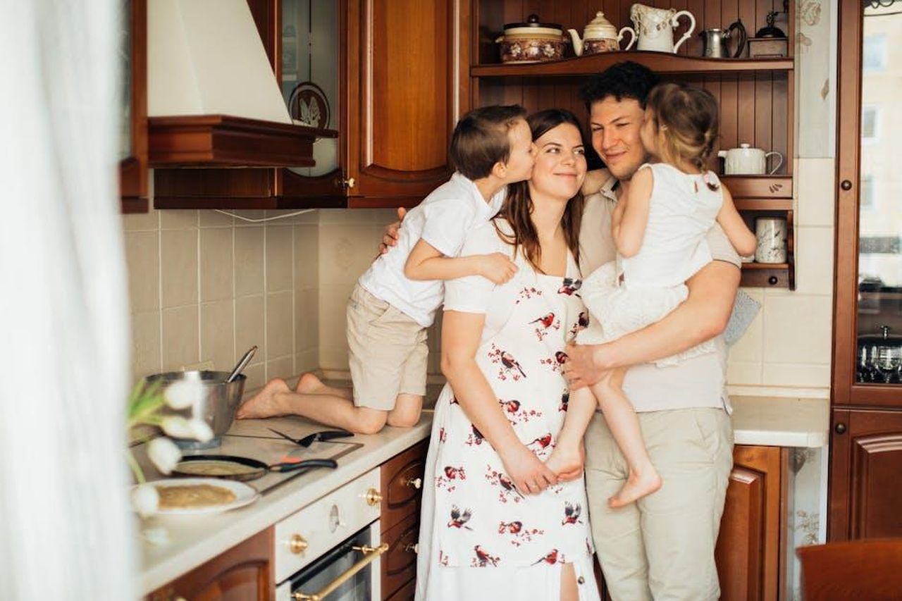 Il_punto_sulla_classifica_Crotone_dopo_il_ko_contro_lAvellino_la_vetta_ora__lontana_a_11_punti_2tA55YOrRc - Confidenze24 Source: Elina Fairytale - pexels - Joyful family moment embracing in a warm kitchen setting with smiles and affection.