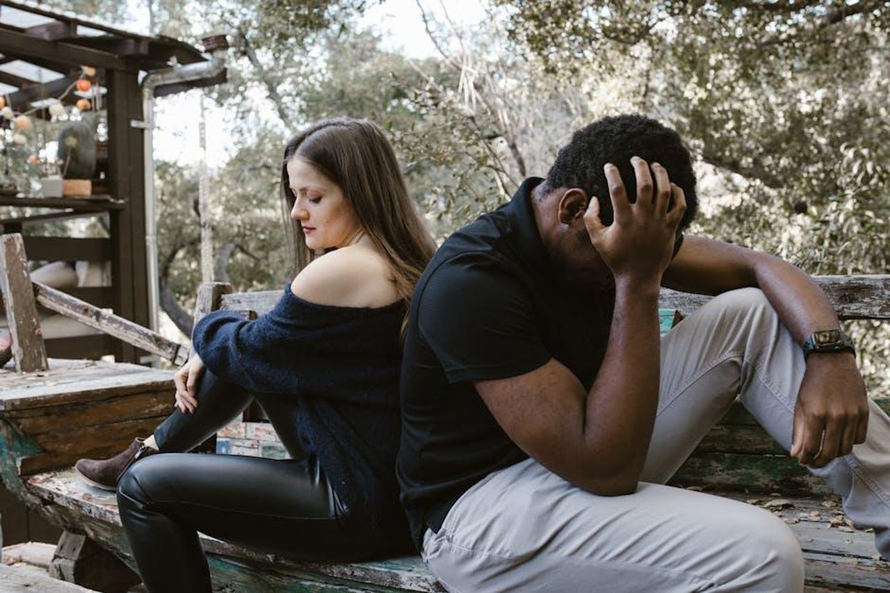 Il_rapporto_turbolento_tra_Mimmo_e_Agata_kjHxDJ117h - Confidenze24 Source: RDNE Stock project - pexels - A couple sits back to back on a bench, depicting emotional conflict and loneliness.