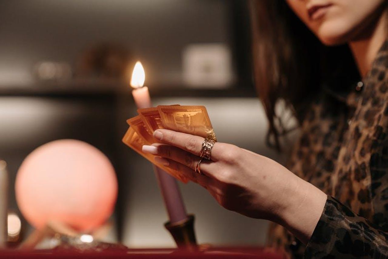 Il_resto_dei_segni_zodiacali_hcyZQVgFfd - Confidenze24 Source: Pavel Danilyuk - pexels - Close-up view of a candlelit tarot reading session, highlighting mystery and focus.