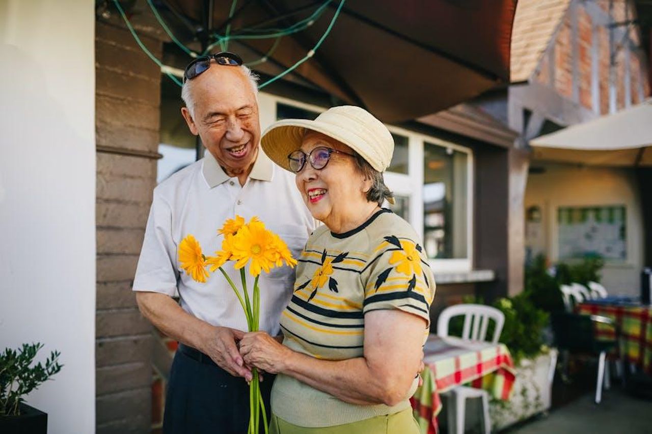 Il_riscatto_un_regalo_e_una_nuova_proposta_K0oNwi7YJj - Confidenze24 Source: RDNE Stock project - pexels - Happy senior couple enjoying a moment with yellow flowers outside a restaurant.