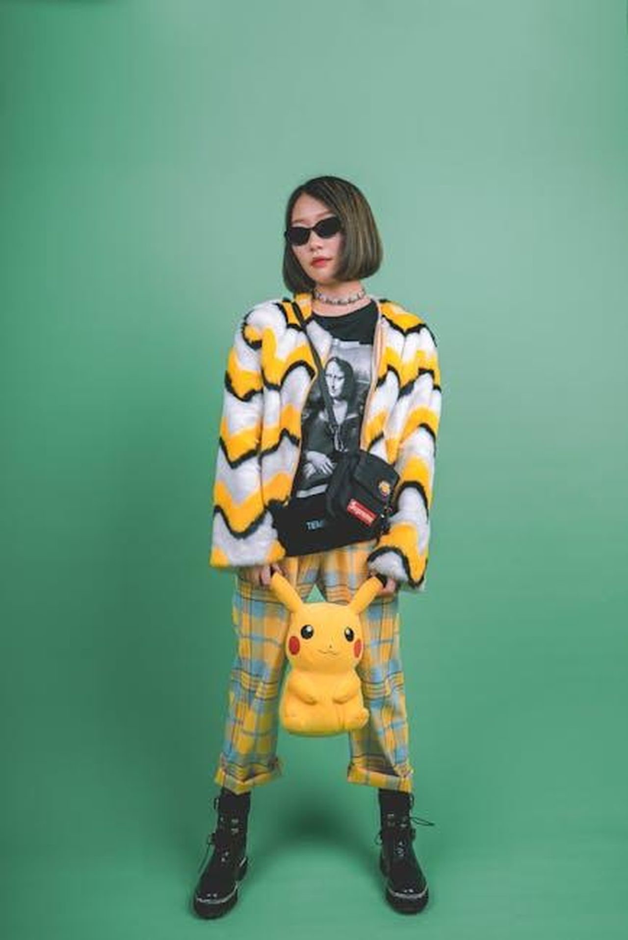 Il_ruolo_di_Clooney_nel_dibattito_politico_Lht1JovJ2d - Confidenze24 Source: mikoto.raw Photographer - pexels - Fashionable woman in a colorful outfit, holding a Pikachu plush, posing against a green backdrop.