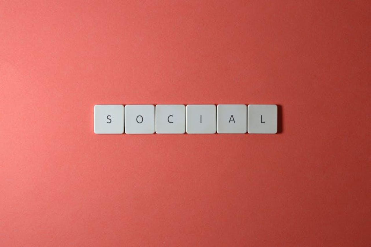 Il_silenzio_social_degli_autori_JNat2VO3mV - Confidenze24 Source: Miguel Á. Padriñán - pexels - Close-up of the word 'SOCIAL' formed with tiles on a red surface, offering copyspace.