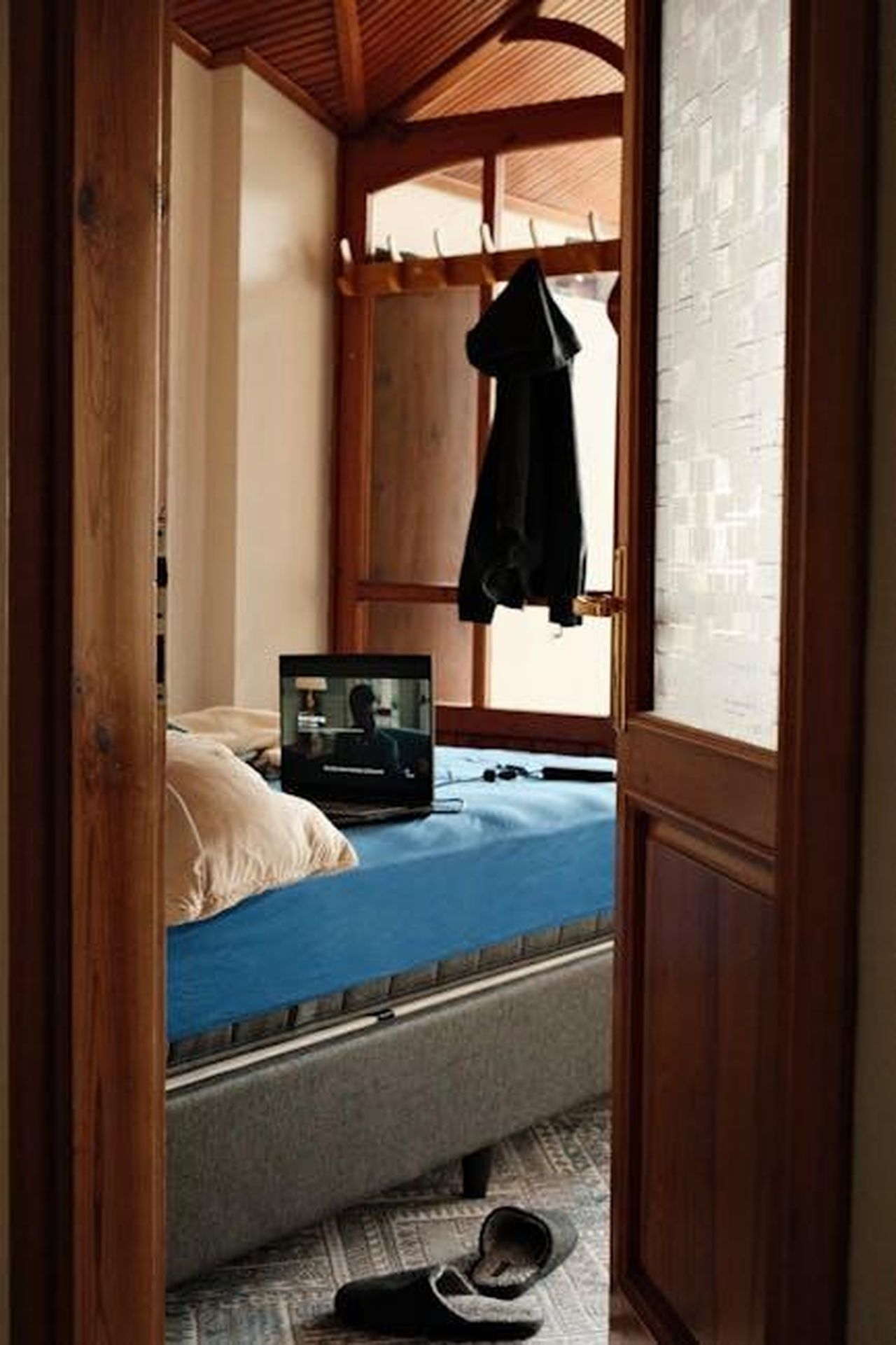 Il_successo_di_Tracker_e_i_numeri_di_ascolto_kZh2fFFewr - Confidenze24 Source: Tahir Osman - pexels - Warm bedroom interior with TV on blue bed, open door view.