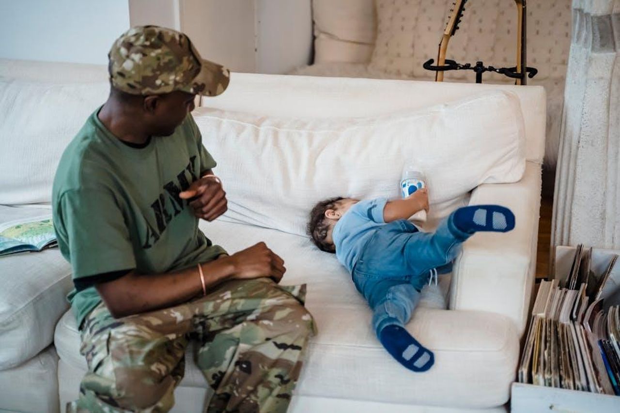 Il_supporto_del_Regno_Unito_per_i_militari_feriti_8UXcIugj9X - Confidenze24 Source: George Pak - pexels - A soldier and his son spending quality time on the couch at home.