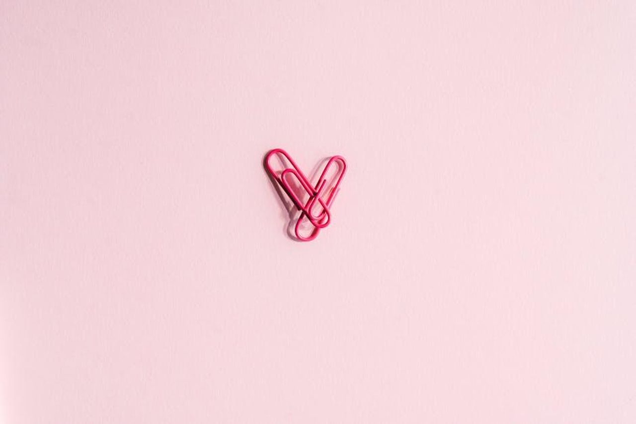 Il_triangolo_amoroso_tra_Zeudi_Helena_e_Javier_Clmbs5jSuy - Confidenze24 Source: SHVETS production - pexels - Minimalist image of pink paper clips forming a heart shape on a pastel pink surface.