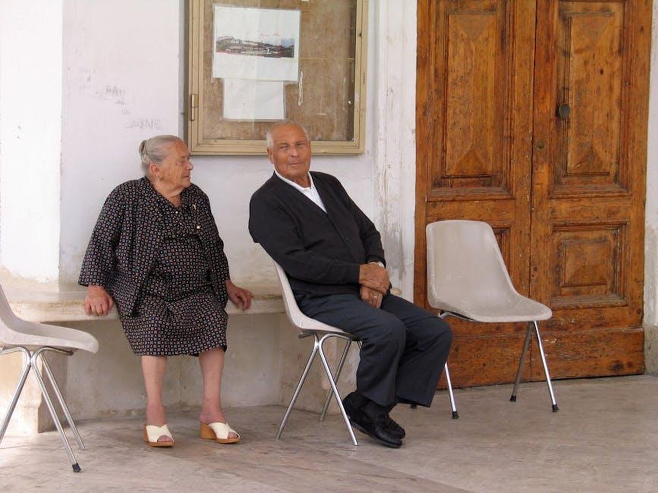 Il_web_si_ribella_Javier_sotto_attacco_1K5iJqKJSq - Confidenze24 Source: Roman Biernacki - pexels - Elderly couple sitting on chairs outside an Italian building, conversing.