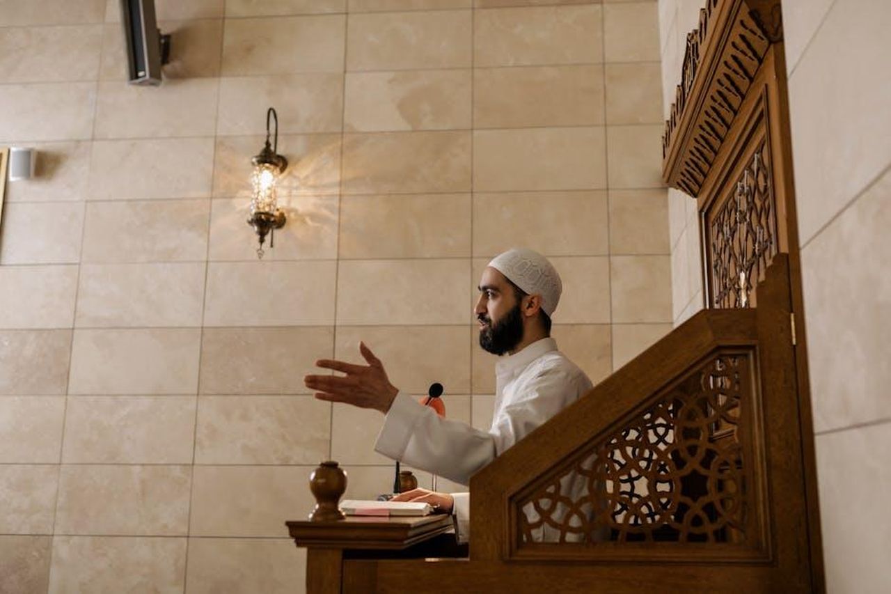 Imma_Tataranni_4_lattrice_ai_ferri_corti_con_lautrice_3vtvPf3zoM - Confidenze24 Source: Alena Darmel - pexels - An imam delivering a sermon from a wooden lectern inside a beautifully decorated mosque.