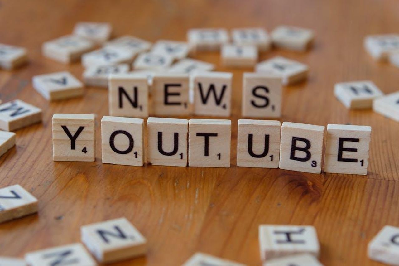 In_The_Style_non_paga_le_spese_agli_influencer_rkSo2nAClJ - Confidenze24 Source: Markus Winkler - pexels - Scrabble tiles spelling words on wooden surface, focusing on YouTube and News.