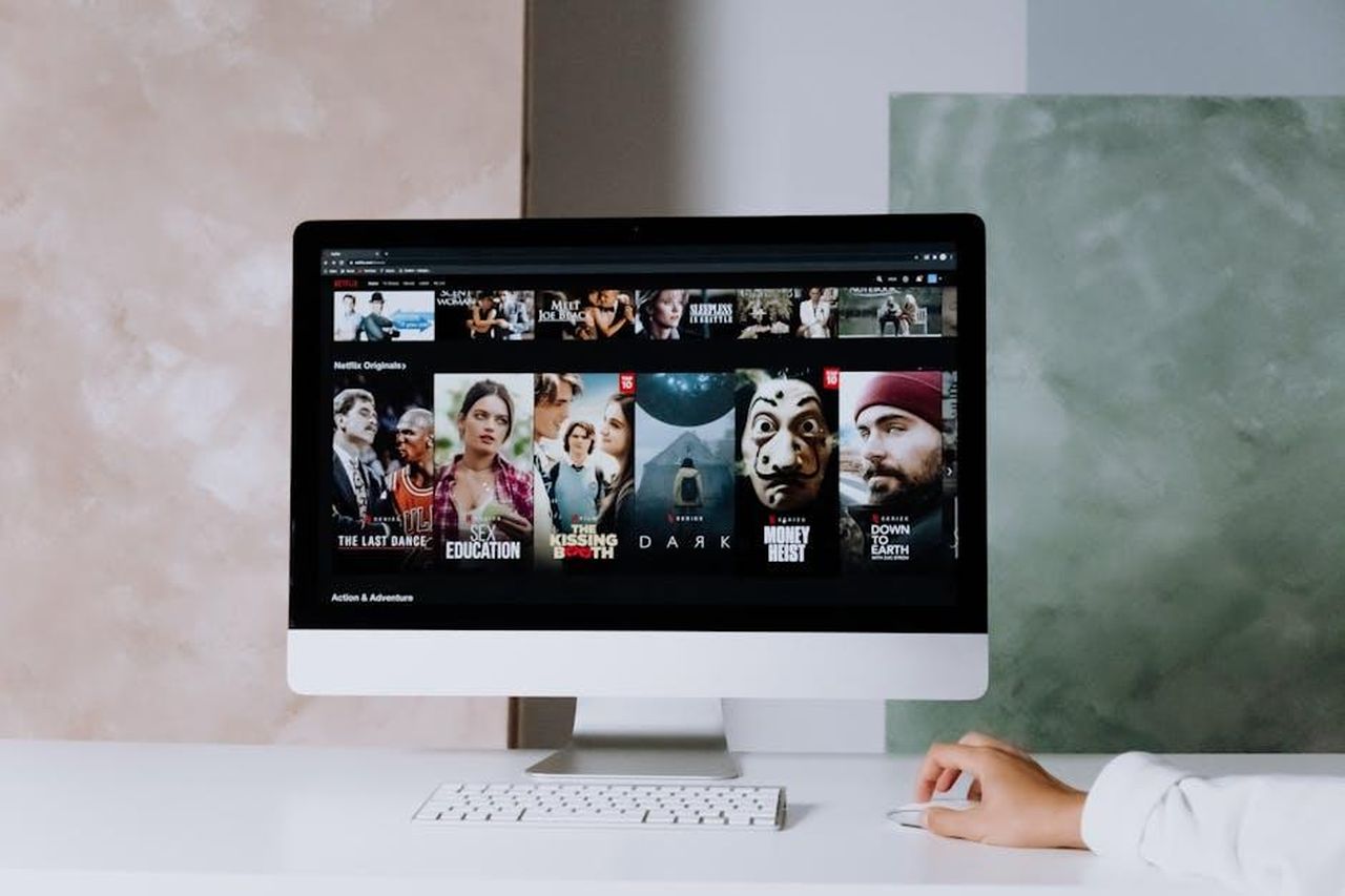 In_estate_potrebbe_arrivare_una_nuova_soap_al_posto_de_Il_Paradiso_delle_signore_cmtyLh76bV - Confidenze24 Source: cottonbro studio - pexels - A modern workspace featuring a desktop screen displaying popular streaming series on Netflix.