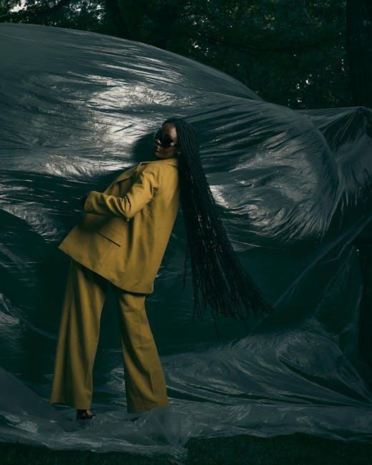 Intervista_e_Stile_Personale_P2w4EnUjYo - Confidenze24 Source: Bllack Artist - pexels - A fashionable woman poses outdoors in dramatic lighting with a stylish outfit and long hair.