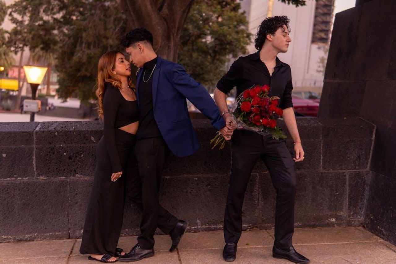 Julia_Goulding_anticipa_la_morte_di_David_6xGdHGxPu6 - Confidenze24 Source: Israyosoy S. - pexels - Three people caught in emotional love triangle outdoors at sunset.