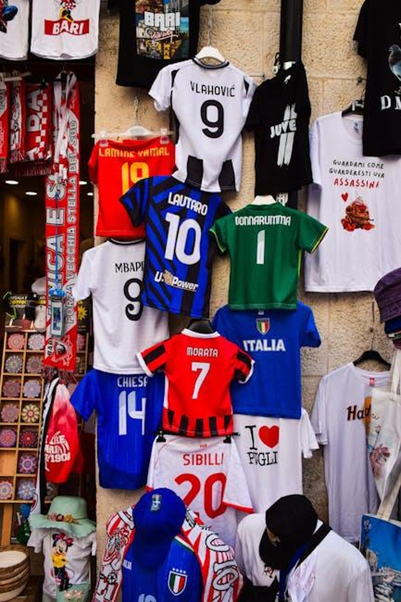 Juventus_Capuano_Vittoria_legittimata_dai_bianconeri_dopo_aver_sviluppato_tante_occasioni_e_aver_dominato_il_campo_p2Ki53uOeN - Confidenze24 Source: AXP Photography - pexels - A vibrant street stall showcasing popular football jerseys in Apulia, Italy.
