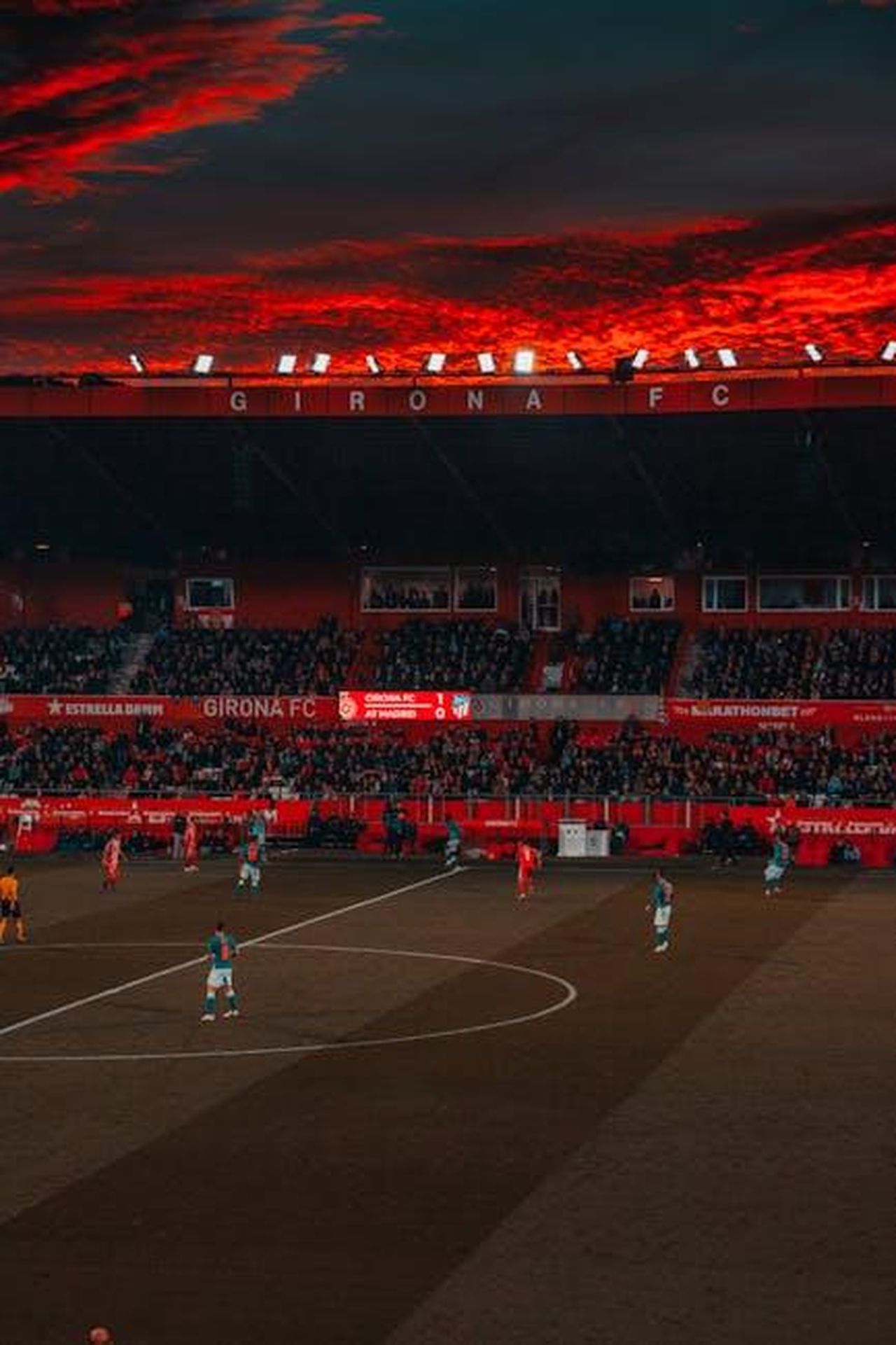Juventus_Giuntoli_tiene_sempre_caldi_i_nomi_di_Hancko_e_di_Comuzzo_pWUk5aKA0G - Confidenze24 Source: Unknown User - pexels - Dramatic evening soccer game at Girona FC stadium with vibrant red sky and intense play.