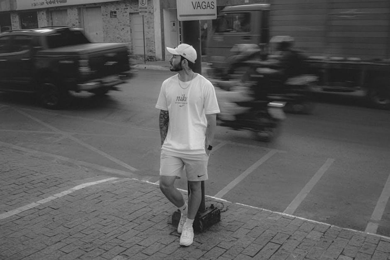 La_Reazione_di_Nikki_Mudarris_DlcuB0zCmv - Confidenze24 Source: Jean Carlos - pexels - Black and white photo of a man waiting on a city street in Barreiras, Brazil.