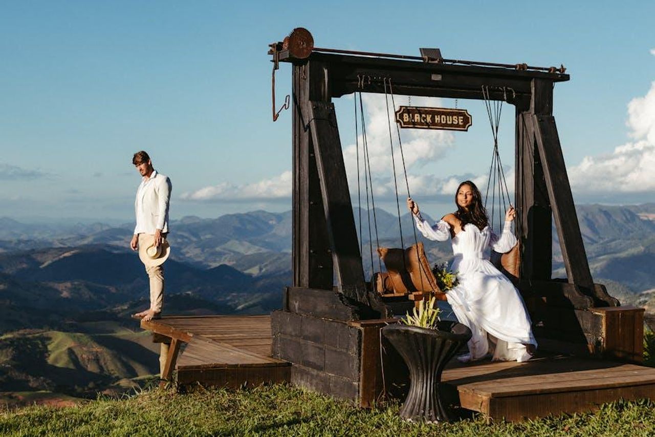 La_Relazione_di_AJa_e_Bam_Un_Anno_di_Speculazioni_0QQIlk52zI - Confidenze24 Source: Jonathan Borba - pexels - A couple enjoys a scenic mountain view from a rustic swing set on a wooden deck.