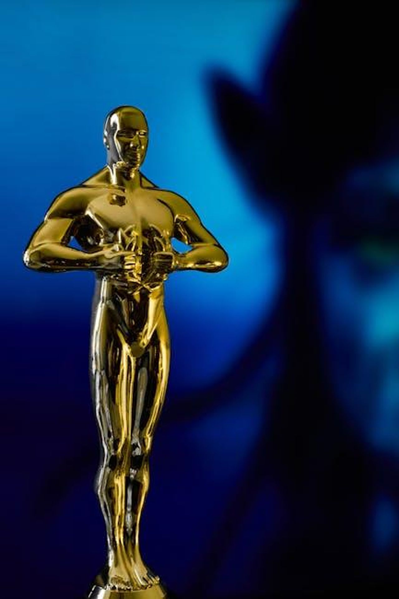 La_confusione_nella_corsa_per_la_miglior_attrice_VhSfxC4BBV - Confidenze24 Source: Mirko Fabian - pexels - A shining Oscar statuette, symbolizing achievement in the film industry, against a vibrant blue backdrop.