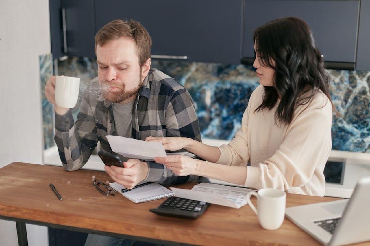 La_crisi_e_la_rottura_PIKalUOWAJ - Confidenze24 Source: Mikhail Nilov - pexels - Couple discussing financial documents and budgeting at a kitchen table.
