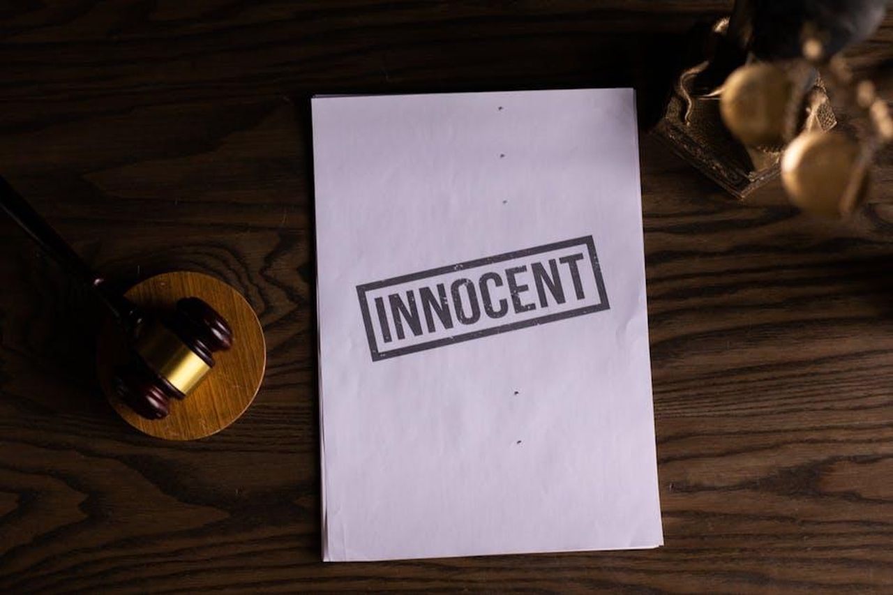 La_difesa_di_Delmastro_7QR9ICpPab - Confidenze24 Source: KATRIN BOLOVTSOVA - pexels - Close-up of legal document stamped 'Innocent' beside a gavel on a wooden desk.