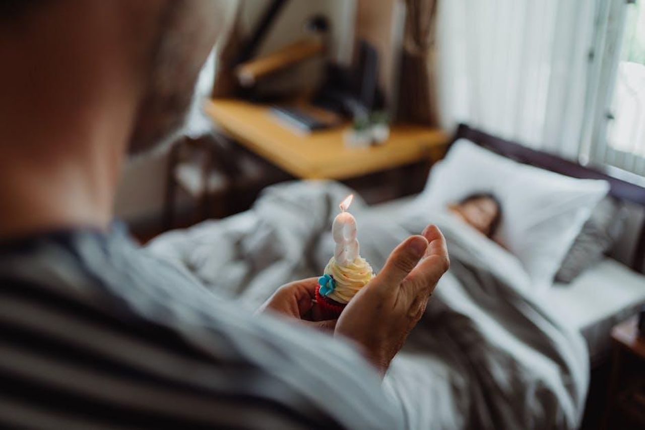 La_festa_a_sorpresa_per_il_traguardo_di_Marcello_CY2n53kBdd - Confidenze24 Source: Ketut Subiyanto - pexels - A father surprises his daughter in bed with a birthday cupcake. Morning celebration indoors.