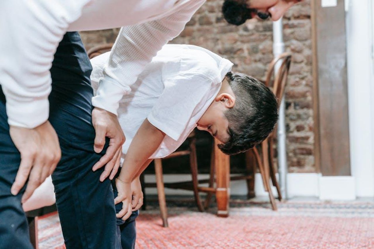 La_lezione_di_vita_che_ho_imparato_cTNCxfGuIY - Confidenze24 Source: Timur Weber - pexels - A father and son engaged in a prayer ritual indoors, expressing family bonding and spirituality.