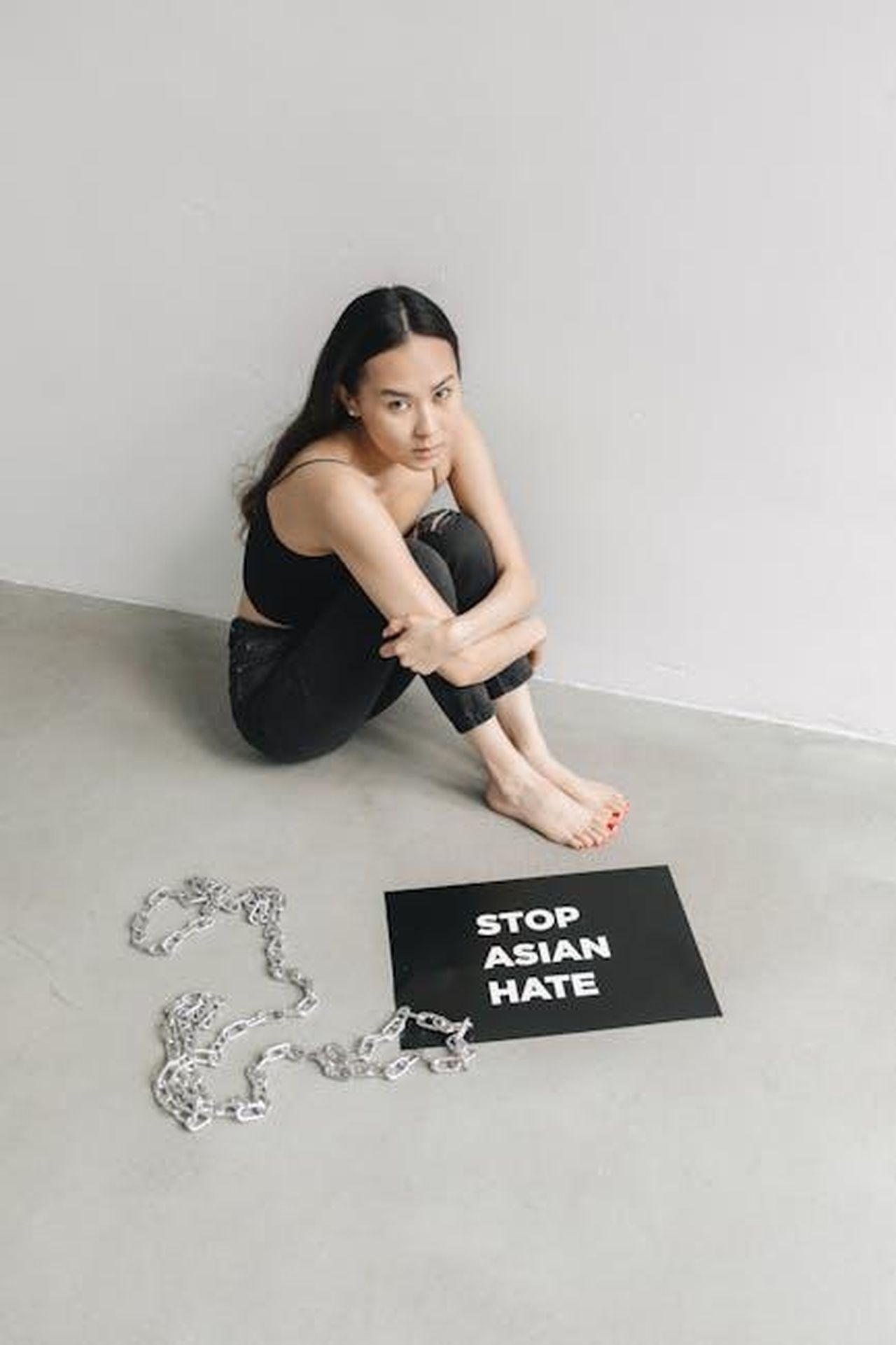 La_lunga_storia_di_post_razzisti_e_fascisti_di_GlomarResponder_jjBkve5d1f - Confidenze24 Source: Polina Tankilevitch - pexels - Woman sitting on floor with anti-racism sign, advocating to stop Asian hate.