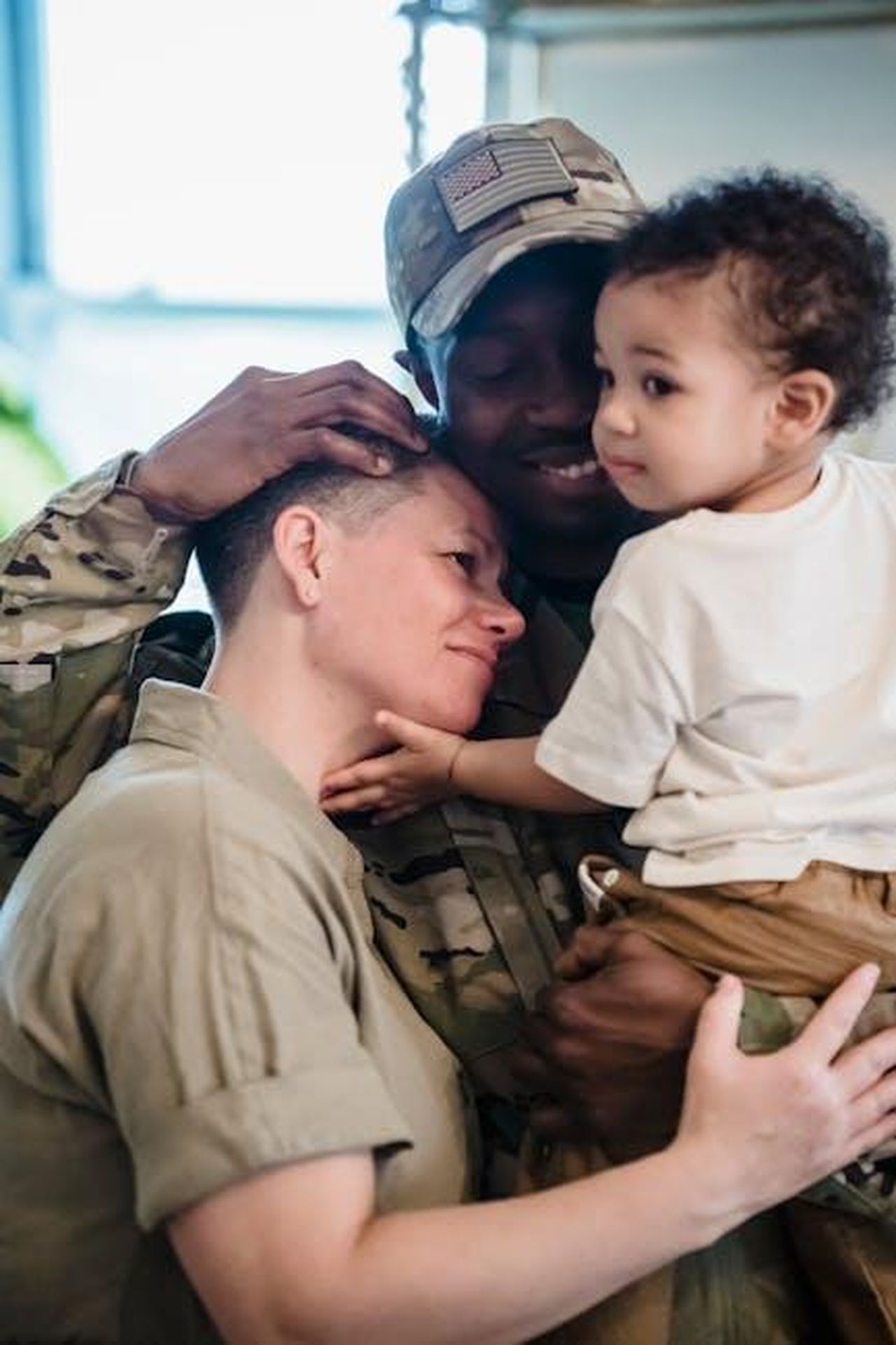 La_mia_famiglia__stata_presente_a_16_anni_stavo_per_andare_in_USA_ma_ho_avuto_un_attacco_di_panico_xIjVV2XNUK - Confidenze24 Source: George Pak - pexels - A heartwarming moment of a family reunion with a soldier in uniform holding a child indoors.