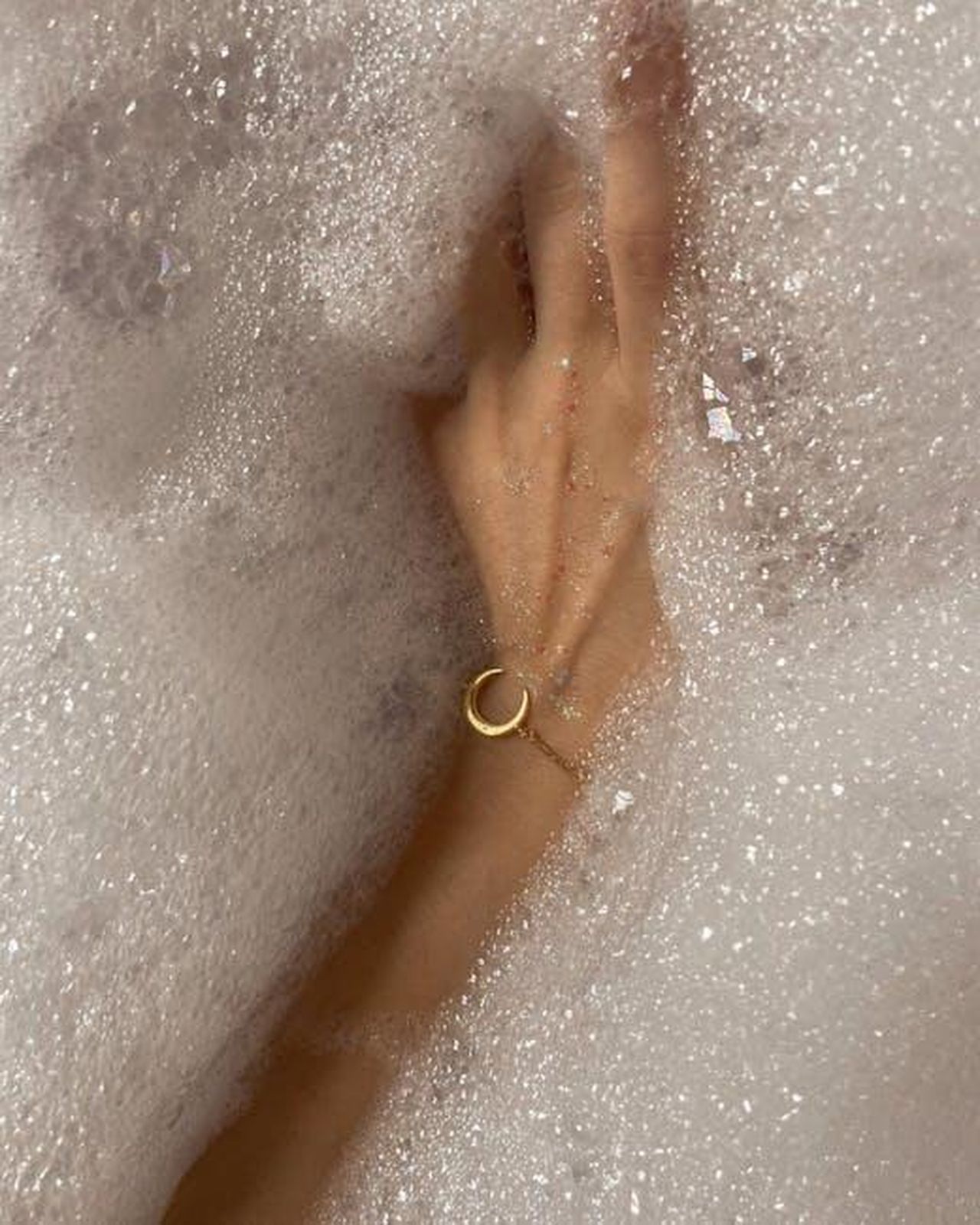 La_morte_di_Yesim_anticipazioni_turche_Tradimento_WWfEtD9RZA - Confidenze24 Source: Mariam Antadze - pexels - A woman's hand with a bracelet submerged in a bubbly bathtub, capturing serenity and self-care.