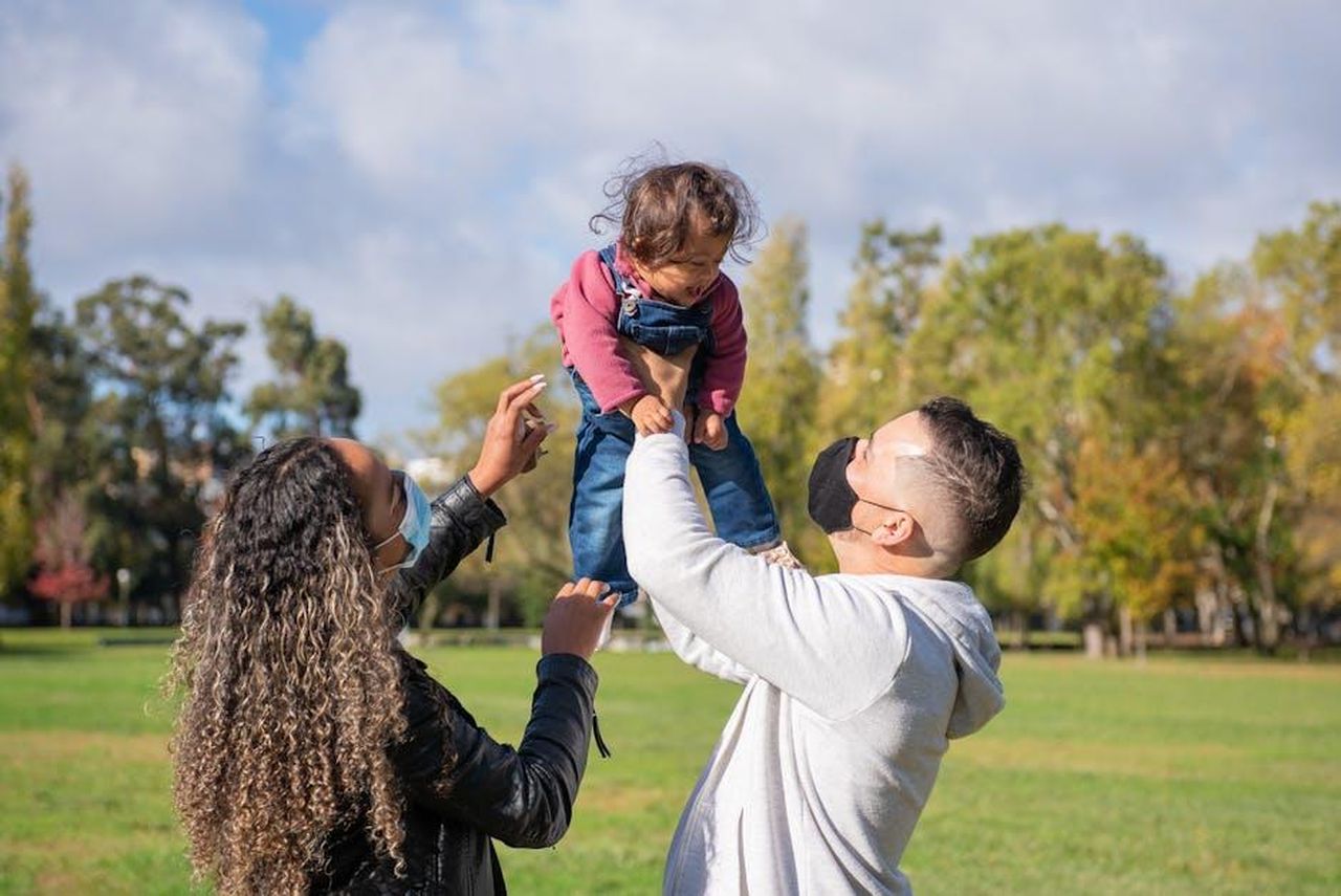 La_precauzione_di_Mark_Ronson_come_nuovo_pap_rZuWdWeAaa - Confidenze24 Source: Kampus Production - pexels - Family bonding outdoors in a park, wearing face masks for safety.