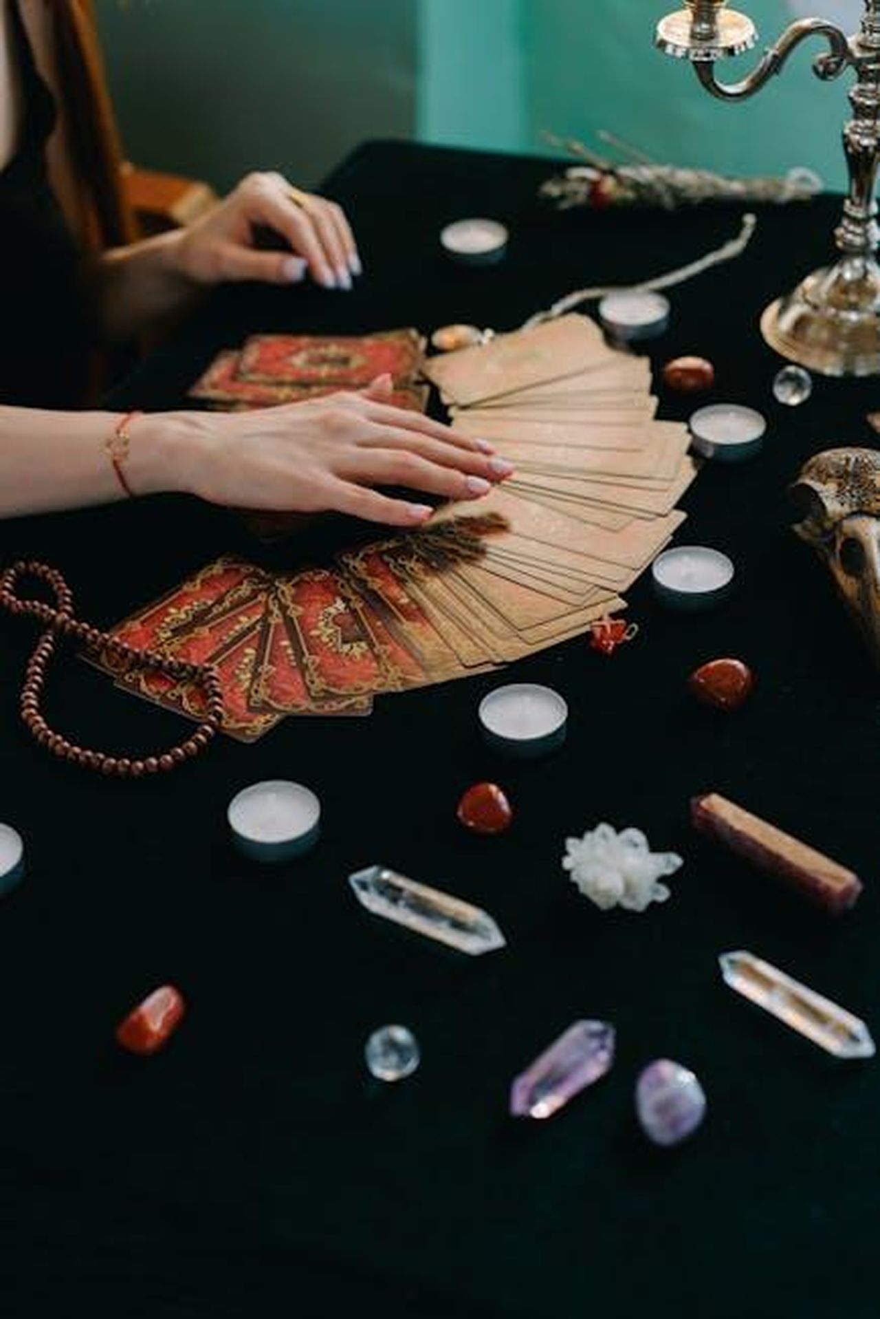La_rivelazione_di_Daniel_7l3mWEPIaF - Confidenze24 Source: Mikhail Nilov - pexels - High angle of crop anonymous female fortune teller with tarot cards and stones with candles during divination process