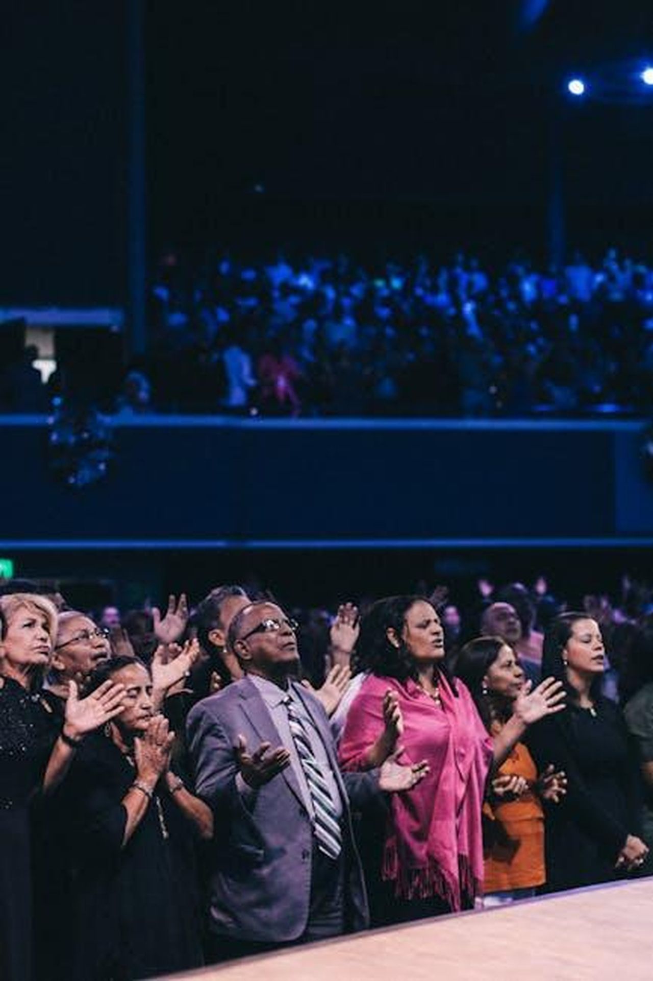 La_rivelazione_di_Mattia_e_la_reazione_degli_altri_concorrenti_oJxEW31q5d - Confidenze24 Source: Luis Quintero - pexels - A diverse group of people participating in a lively worship event in a large auditorium.