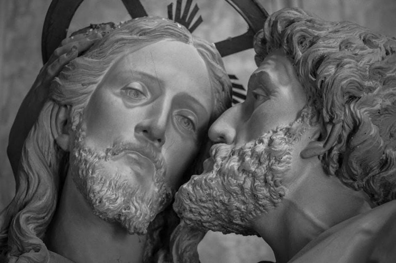 La_scoperta_del_tradimento_amwtJnTsq3 - Confidenze24 Source: MAURO FOSSATI - pexels - Close-up of a sculpture depicting the kiss of betrayal by Judas to Jesus in grayscale.