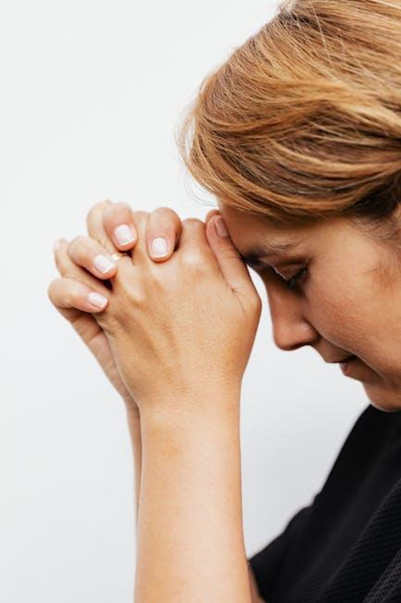 La_speranza_di_un_ritorno_ZIlQOxrBGz - Confidenze24 Source: Photo By: Kaboompics.com - pexels - A thoughtful woman praying indoors, symbolizing faith and reflection.