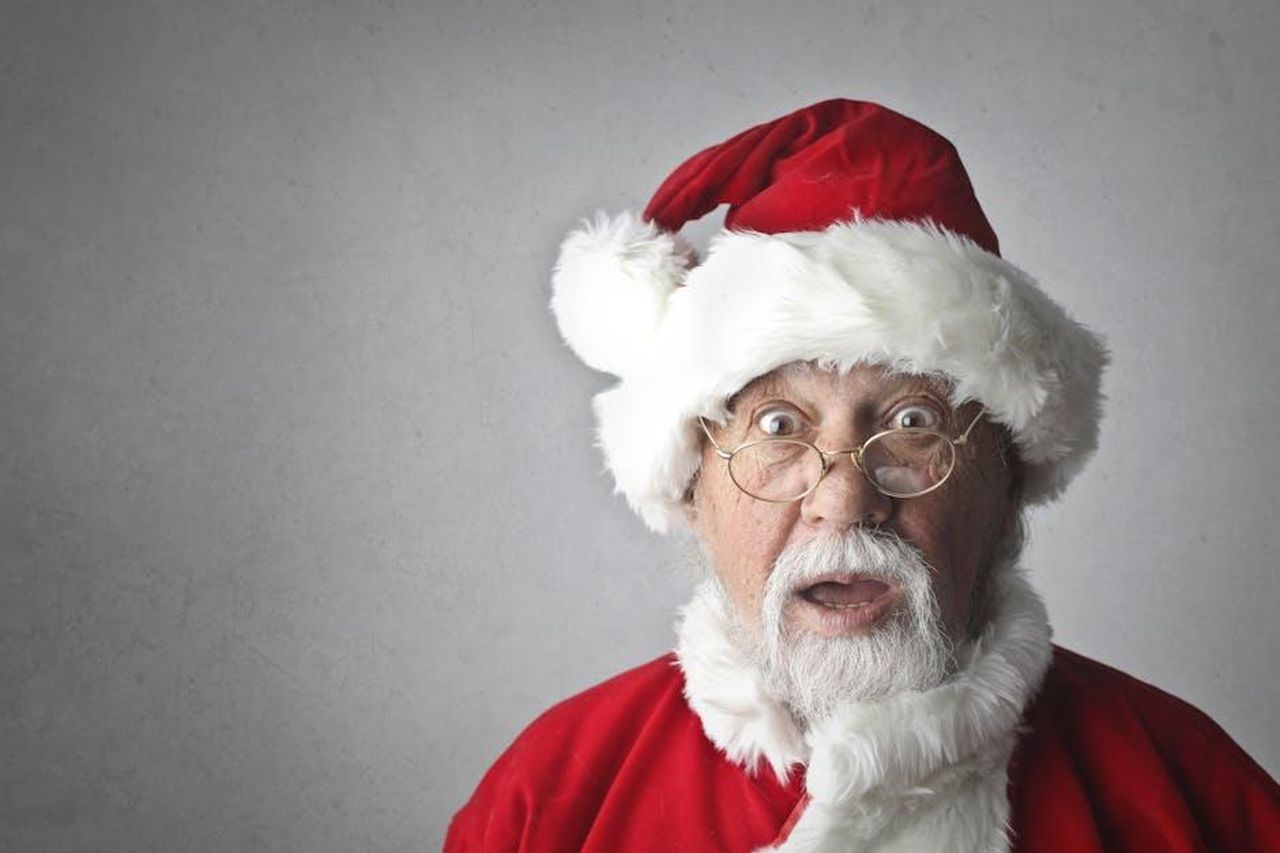 La_verit_su_Babbo_Natale_9nSPOtqNS4 - Confidenze24 Source: Andrea Piacquadio - pexels - A surprised Santa Claus in traditional red outfit and glasses, expressing joy and wonder.