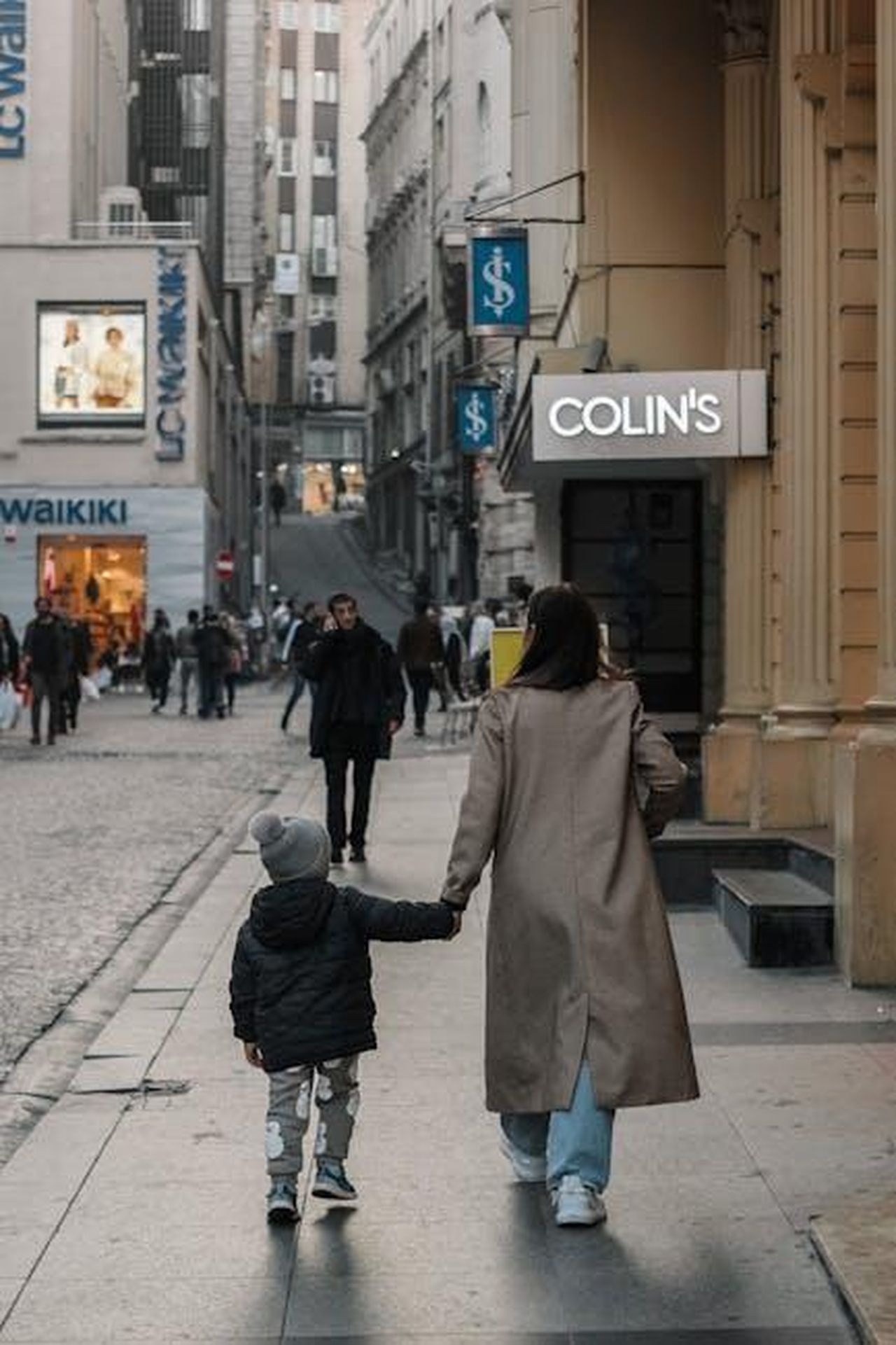 La_vita_familiare_di_Colin_Farrell_8JthiQxm0f - Confidenze24 Source: Ayşenur Tekinel - pexels - A woman and child walk holding hands in a city street during evening.