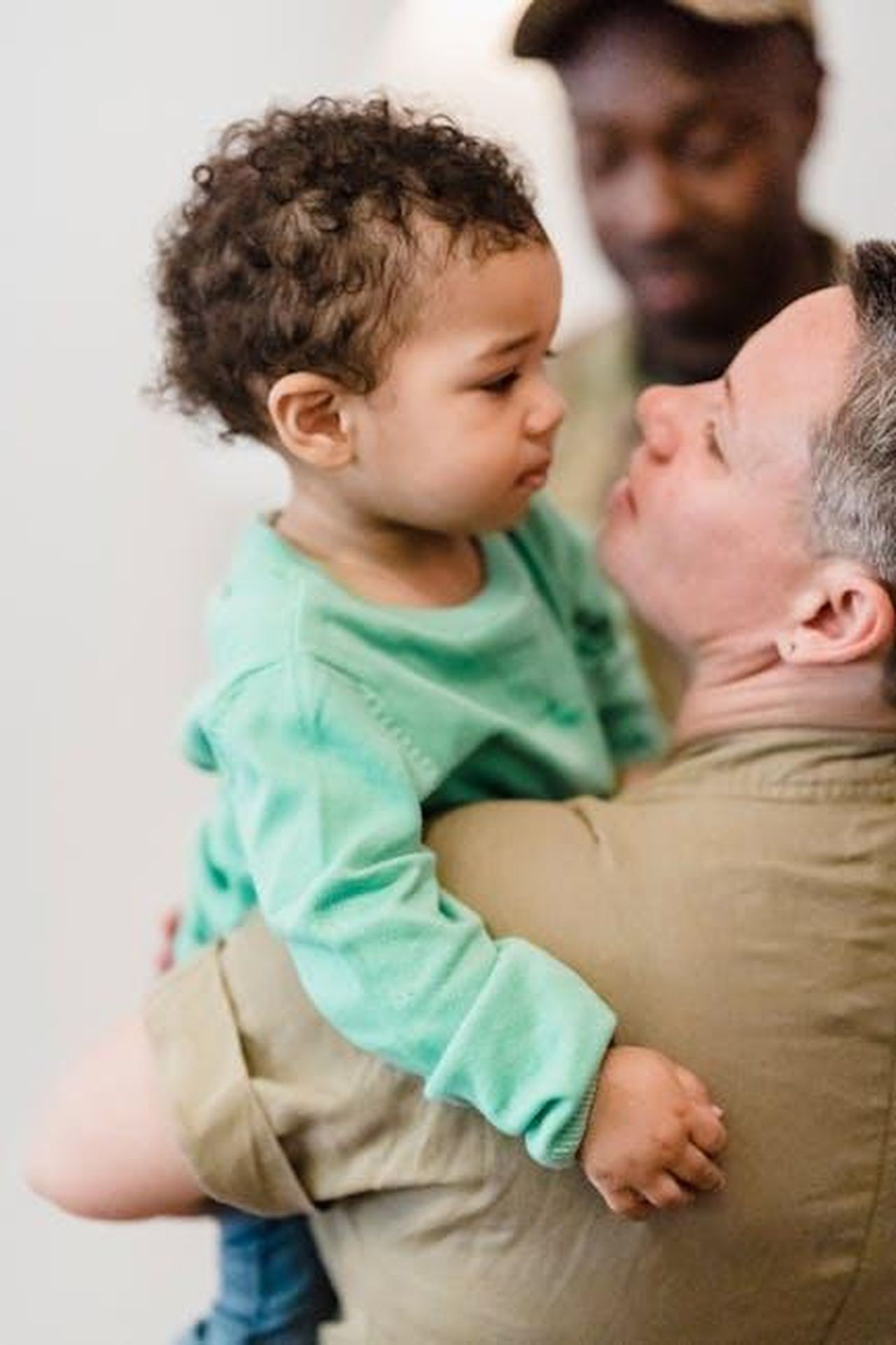 Le_Reazioni_del_Pubblico_e_il_Momento_Emozionante_k66Rb3nZ6x - Confidenze24 Source: George Pak - pexels - A touching moment of family reunion between a military parent and child indoors.
