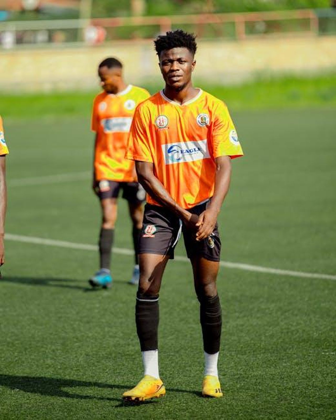 Le_accuse_della_Procura_Bhlk8d2jK5 - Confidenze24 Source: Chris wade NTEZICIMPA - pexels - Young soccer players in orange jerseys on a green field, focused and ready for the game.